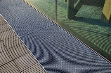 Evin etrafında havalandırma ızgarası var. Bodrum pencereleri yer seviyesinin altında. Metal yürüme ızgarası. Duvarcılıktan ve tuğlalardan nemi temizlemek için temel havalandırma ve drenaj. Durgun ışık, örgü