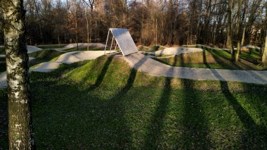 Ormanda bisiklet izleri, eğimli virajlar birbiri ardına mükemmel şekillerde kazılmış dağ bisikletleri çocuklar için bile, açıklık, güneş, gölgeler, yarış yenileri, çimenler...