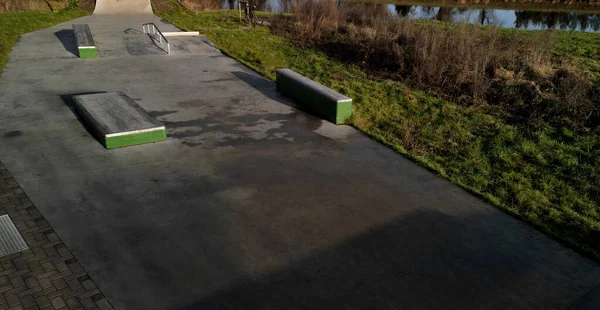 Skateboard park with concrete cement surface with concrete skateboard obstacles is designed for roller sports. Cycling is not allowed except for freestyle bikes.  winter morning sunrise, above, high