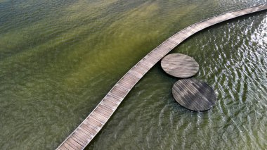 Tahtadan yapılmış yüzen bir yürüyüş yolu. Göl suyunun üzerinde, dibe doğru giden dar kavisli patikalar. Korkulukları yok. Her bir dairesel tahtadan yapılmış daha fazla tasarım yürüme yolu. hava durumu 