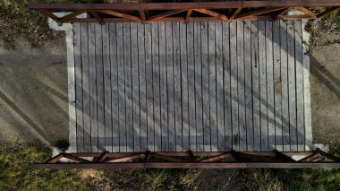 Ahşap korkuluklu bir park köprüsü dereyi geçiyor. Kirişler beton bir temeli tutan çelik bir kirişe sabitlenmiş. Çakıl yolu köprünün önünde, üstte, üstte