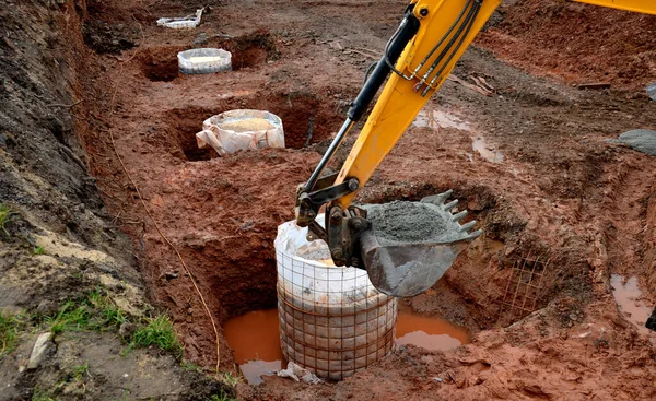 Foundation of buildings using drilled piles for private houses as well as for industrial buildings. the well was drilled either without casing or under a protective steel grating, geotextile