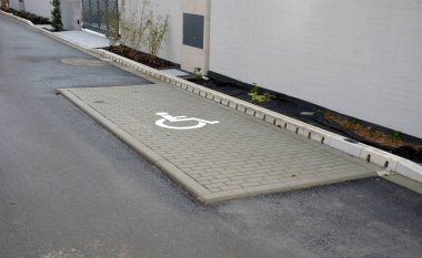 drainage hidden on the edge of an asphalt road Drainage system hidden in a perforated concrete gray curb. the water along the entire length of the road drains into the sewer through holes, grass tying
