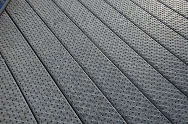 staircase and wide pedestrian bridge with perforated metal floor. galvanized sheet metal with circular holes. white railings like on a ship in the arch. handrail made of polished stainless steel pipe.