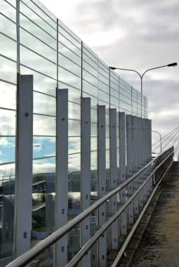 Kuş, sefety, caddede metal kirişlere gömülmüş bir karayolu köprüsünde ses geçirmez mavi cam duvar. Trafik gürültüsü azaldı. Çelik kablolarla insanların üzerine düşmemek için güvenlik koruması