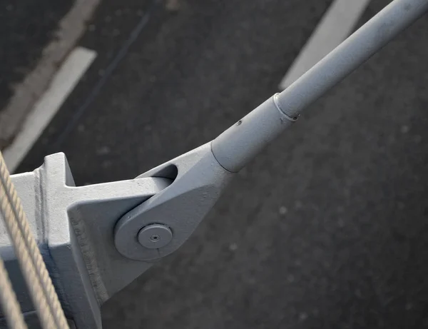 metal rod with pins for fixing the body of the bridge. a white steel pillar on which several gray struts are anchored in a fan-like fashion. roadway suspension bridge structure