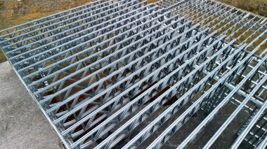 Building construction from metal trusses. lattice structure of the frame of an industrial building. A large thick tangle on the ceiling of a building under construction. shiny metal profiles steel