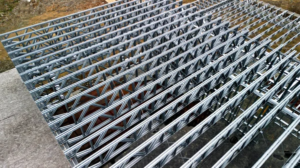 Building construction from metal trusses. lattice structure of the frame of an industrial building. A large thick tangle on the ceiling of a building under construction. shiny metal profiles steel