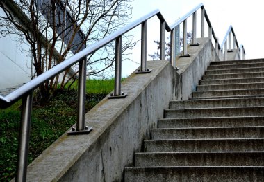 staircase with concrete sides at a public building. the safe staircase has two handrails, one with a reduced height for children under 12 at the entrance to the school, drone view, top, point of