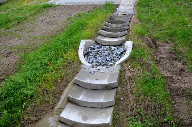 freeway bridge drainage. A sound-absorbing wall with holes lets water through. gutters collect water from gutter of water line. pipe with flexi rubber connection. slowing down flow water roughening