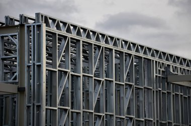 Building construction from metal trusses. lattice structure of the frame of an industrial building. A large thick tangle on the ceiling of a building under construction. shiny metal profiles steel
