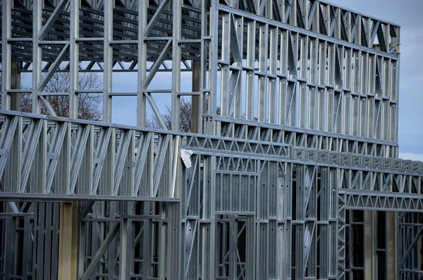 Building construction from metal trusses. lattice structure of the frame of an industrial building. A large thick tangle on the ceiling of a building under construction. shiny metal profiles