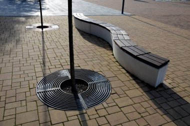 Beton beyaz bank bloğu ve parkta dalga şekli koyu renkli bir meydanda, temiz beton yüzey gri kahverengi beyaz yayalar ve kaykay parkında gençler için dinlenme alanı.