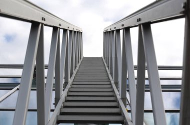 Tavan penceresinin üstündeki camları silmek için alüminyum köprü. Büyük seraların ve tavan pencereli galerilerin yıkanmasını kolaylaştırmak. Merdiven rayların üzerinden geçebilir, mavi gökyüzü, mala