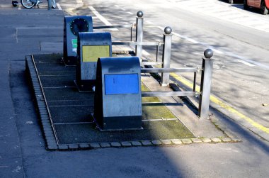underground waste sorting containers are created. they do not take up so much space in a square or square. the crane pulls out the whole container and dumps it. paving of gray concrete, post, sphere