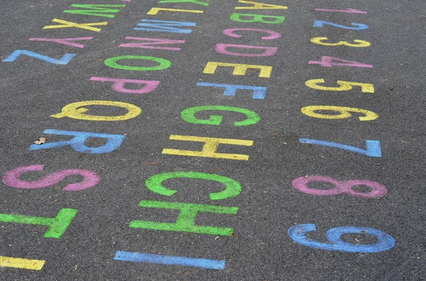 Playground for preschool children. an alphabet of colored letters and a number series for teaching purposes. color each letter different on asphalt pavement, square. roman