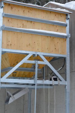 wooden hopper and metal frame with flap. pours gravel or salt directly onto the back of the car. winter maintenance of roads and sidewalks. warehouse for sprinkling material for maintenance of road