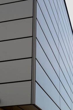 cladding of a building with a expanded metal lattice structure. galvanized gray nets protect the industrial building. Blue sky in contrast to a silver background, wall, corner, slanted, sheet metal