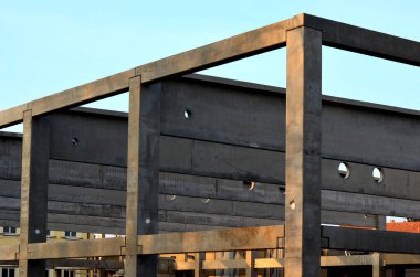 construction of concrete structure of industrial hall of warehouse. the concrete feeder arm from the mixer bends over the beams and columns. pipe conveyor on the crane.excavator, tractor, yellow