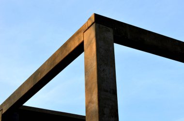 construction of concrete structure of industrial hall of warehouse. the concrete feeder arm from the mixer bends over the beams and columns. pipe conveyor on the crane.excavator, tractor, yellow