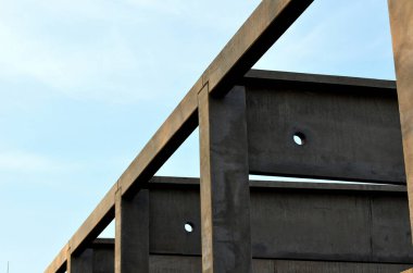 construction of concrete structure of industrial hall of warehouse. the concrete feeder arm from the mixer bends over the beams and columns. pipe conveyor on the crane.excavator, tractor, yellow