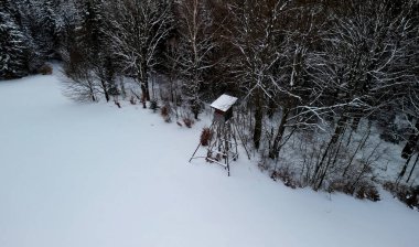Ormanın kenarındaki bir av tüneği geyik, yumurtlayan geyik, tüfekli yaban domuzu gözlemlemek ve vurmak için uygundur. Kayın ve ladin, pencere, kulübe ve baraka ile karışık bir ormanın yakınındaki karlı çayır.