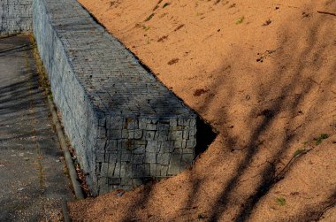 Ev çitlerinin bir parçası olarak bir Gabion istinat duvarı inşa etmek. İşçiler jeotextil koyuyorlar ve üzerine granit taşlardan oluşan tel sepetler koyuyorlar. talep edilen el işi