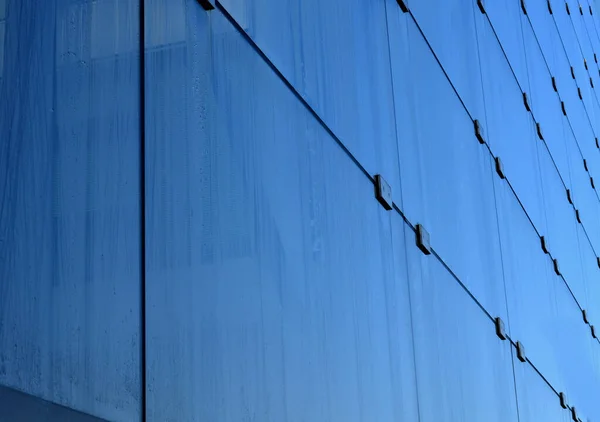 stock image washing windows with a spatula on a long handle. Large glass office buildings are washed from the platform by a company specially hired by company, glasshouse, greenhouse, noise barrier