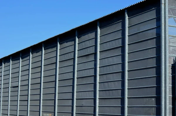 steel cladding of a building with a expanded metal lattice structure. galvanized gray nets protect the industrial building. Blue sky in contrast to a silver background, warehouse