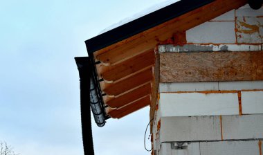 Evin ön cephesinin tamiri. İnşaat iskelesi evin hemen yanında. Mineral yün termal yalıtımlı yalıtım. Tavan arası ve kiremitleri yanmış çatı büyük bir termal dirençtir.