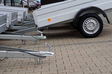 Kiralık dükkandaki otoparkta bir arabanın arkasında karavan. Sadece çekici aletin topuna koşum takımı. Homologlama ve teknik teftişler. Metal yan paneller, kilitli zincir, asma çubuk
