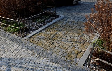 Meydandaki ağacın altındaki kaldırımda kirli, soğuk sallanan sandalye. Parktaki tek bir kişi için tropikal ahşaptan yapılmış ahşap sandalyeler. Kar, küp, kahverengi tahtalardan yapılmış rahat çelik çerçeveler, çam