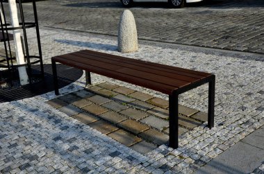 Kare şeklindeki silindirde taş bariyerler ve üstünde de bir yarımküre var. Granit kaldırımlar otoparkta duruyor. Zincirleme çit, yayalar ve taşlı araçlar kolonisine karşı.