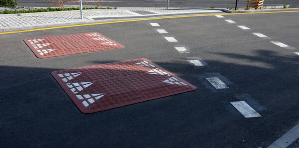 A speed hump is an artificially raised spot on the roadway, the aim of which is to force drivers of road vehicles to drive slowly. It is usually used in combination with speed limit road signs