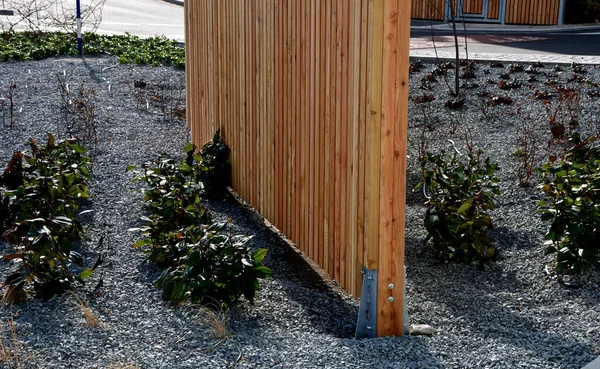 草で作られた黒い金属棒の組み合わせで豪華なフェンシング垂直アーチに折り畳まれています 木は金属の棒の間にあり透明な壁を形成しています 庭にはプライバシーがあります — ストック写真
