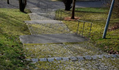 Granit bloklardan yapılmış merdivenler çimlerle kaplanmış. Merdivenler, demir parmaklıklar ve tırabzanlar ile doğal bir doğaya sahiptir. Tepenin aşağısındaki çayır ağaçları.