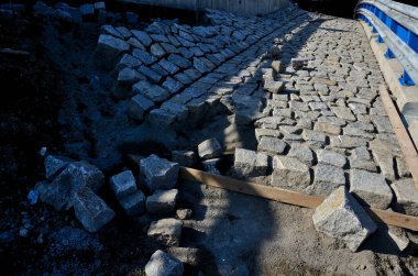 Yeni inşa edilmiş bir yol, üst üste dizilmiş perdeli ve asfalt halı katmanlarını görebilirsiniz. Çevresindeki alan beton oluğu olan bir hendeğe saplanmış. yağmur suyu drenajı