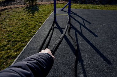 Boks ve spor salonu için antrenman alanı. Spor salonu halkaları, halatlar ve merdivenlerle egzersizler. Burada bir kum torbası asılı. Erkekler vücudu, kasları eğitir. Yumruk ve kickboks, çimen