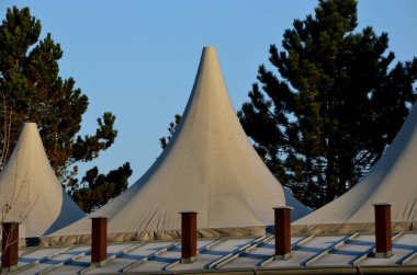 Beyaz tente gergin, güneşten gölgeleniyor ve restoranın terasında yağmur yağıyor, çocuk parkında, platformda. Sadece bir direk ve gergin, ahşap sütun, mavi gökyüzü