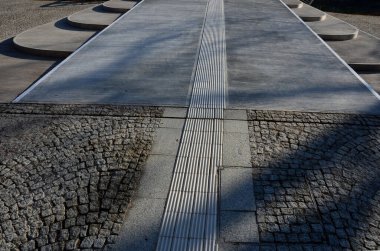 Rıhtıma doğru adım at. Kapıdan giriyorsunuz, bir rampa üzerinde, kenarlarda çelik levha kenarlı kemer şeklinde merdivenler var. körler için çentikli kiremitler