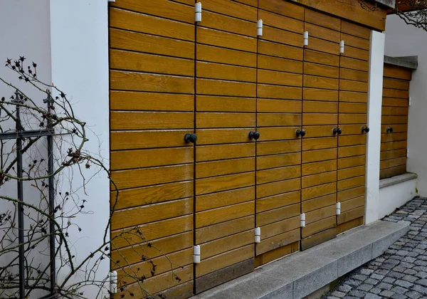 stock image wooden shutters for arch-shaped balcony windows. the Italian style of the baroque castle and the courtyard paved with granite pavement. hidden for garbage cans in front of the house. does not spoil 