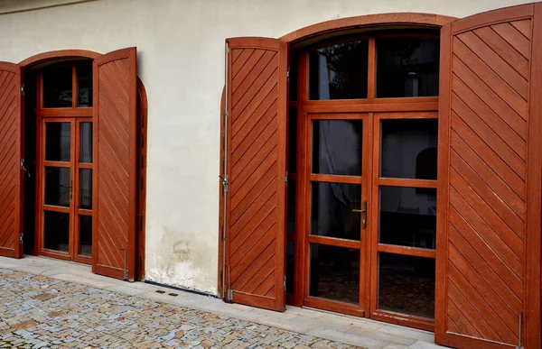 wooden shutters for arch-shaped balcony windows. the Italian style of the baroque castle and the courtyard paved with granite pavement. hidden for garbage cans in front of the house. does not spoil