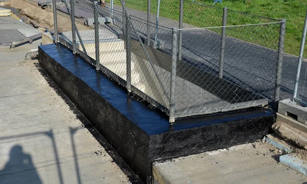 带沥青涂层的绝缘混凝土护栏 地下车库楼梯的镀锌铁丝网围栏 — 图库照片