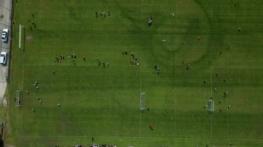 Birkaç golle spor stadyumu forbol maçı. Buradaki çocukların bir dizi eleme okulu derecesi maçı var. Sürüyü dikey olarak aşağıya doğru gözlemleyin. biçilmiş çizgili çimenler