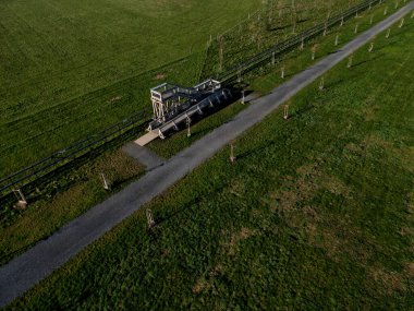 observation tower platform made of oak logs with barrier-free access for seniors and the immobile. zoo safari with a large paddock and terrace for tourists, aerial, high angle view, upper, education