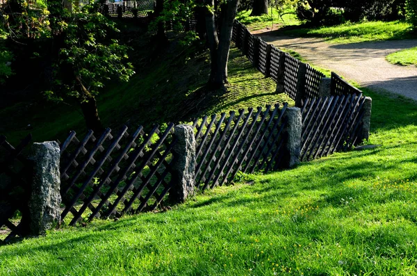 old-fashioned garden fencing. stone posts with mortise directly from the quarry, between which is inserted a wooden fence with a diagonal latticework