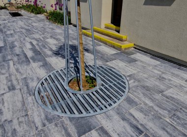 Adayı şeritler arasında bölen yaya geçidi. Yol işaretli kemerler, cadde boyunca kurumuş çiçeklerle dikilmiş. Bahçıvanlık. Lüks taş kaldırımlar, kaldırım taşları, daire, örtü