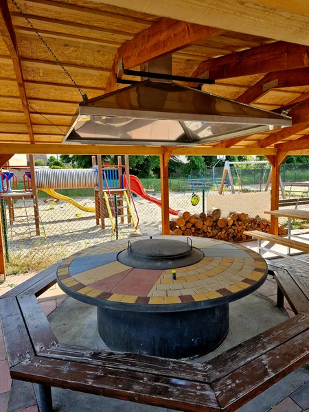 暖炉のあるテーブルがモザイクで覆われた円形のテーブルがある屋根の煙突 窓の上には煙突に煙を導く広い漏斗があります — ストック写真