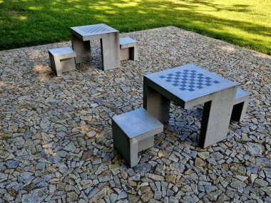 wooden oak prism bench in garden. for better drying of wood, grooves are milled lower part, which prevents tension and cracking of beam in park. side view, table tennis, fence rope, post, fir, abies