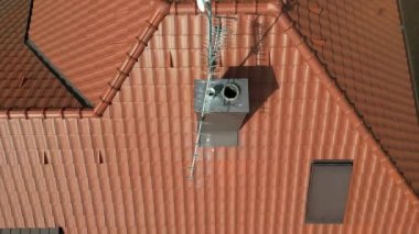 İHA kullanarak bacanın temizliğini kontrol etmek. Temizlik güvenlik ve kurum ateşleme riski için gereklidir. Kameralı bir İHA çatıda denetleme yapıyor. Baca işi, kırmızı.